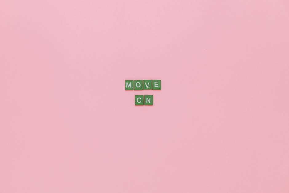 The image features a light pink background with small green letter tiles arranged to spell out the words 'MOVE' and 'ON', with 'MOVE' positioned above 'ON'. The tiles are placed centrally and are clea